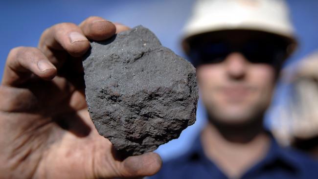 01/01/2009 BUSINESS: Rio Tinto Group worker Duncan Pratt holds a piece of high grade iron ore, showing hemalite crystals, at the Tom Price iron ore mine in Pilbara, north Western Australia on Wednesday, July 26, 2006. BHP Billiton Ltd., the world's largest mining company, is losing the support of investors and steelmakers for its proposed $128 billion takeover of Rio Tinto Group. Photographer: Jack Atley/Bloomberg News