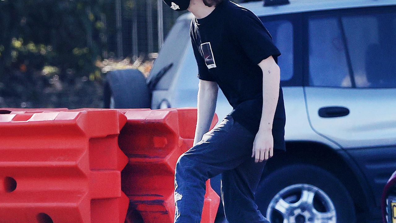 A young skateboarder ducks through the border barricades on Bay St at Tweed Heads.