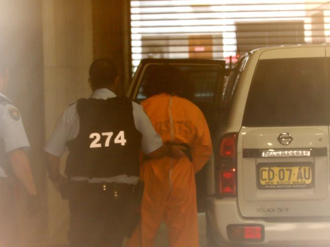 Ahmad Saiyer Naizmand is led from the cells at Burwood Local Court.