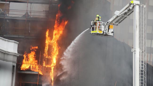 Firefighters hit a building under demolition in Circular Quay. Picture: John Grainger.