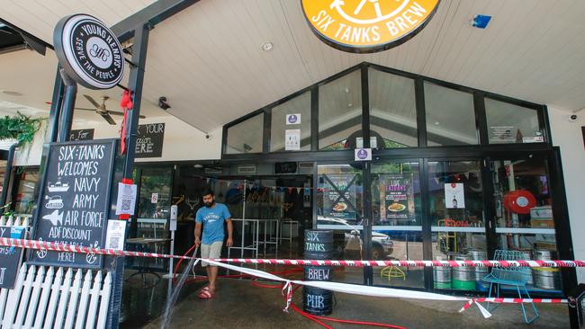 The scene at Six Tanks on Mitchell St on Sunday as workers clean up after a 4WD was driven into the pub’s entrance. Picture: Glenn Campbell