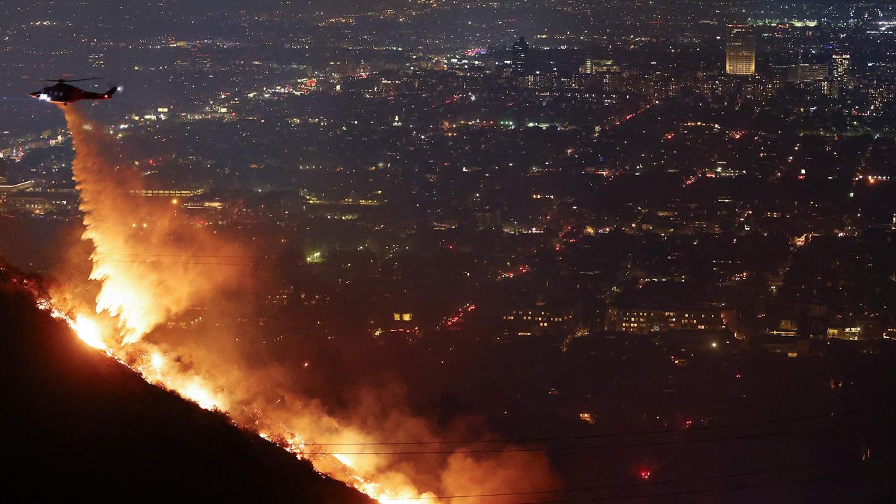 A firefighting helicopter drops water as the fire burns in the Hollywood Hills. Picture: Getty Images via AFP