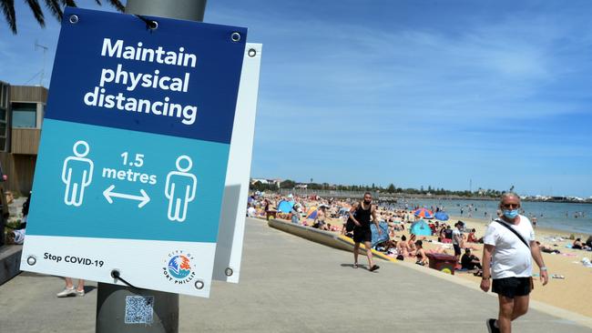 SIgns around the beach are reminding crowds to keep their distance. Picture: NCA NewsWire / Andrew Henshaw