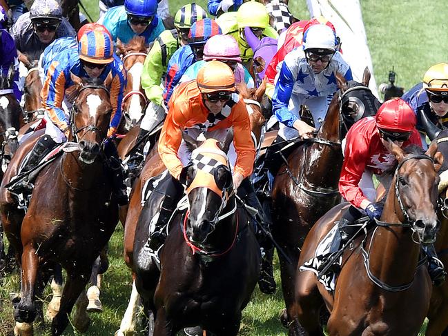 The field go past the post on the first lap.  Kerrin McEvoy (red cap) wins on Cross Counter in the Lexus Melbourne Cup.  Race 7   Melbourne Cup races, Flemington Racecourse.  Picture: Nicole Garmston