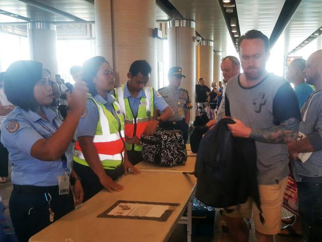 The men depart Denpasar Airport in Bali. Mark Rossiter (front), Ricky Longmuir and Michael Matthews are escorted onto the plane. Picture: Supplied