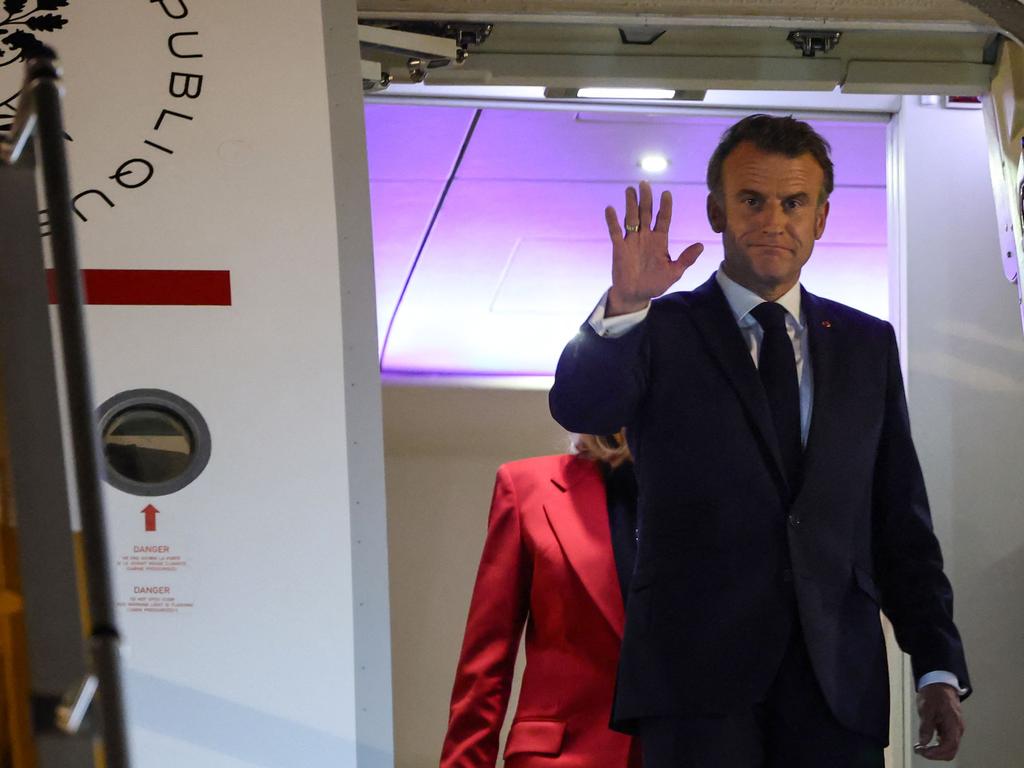 President Emmanuel Macron waves to the waiting media pack, followed by his wife in front Brigitte Macron as they arrive at Noi Bai International Airport in Hanoi, Vietnam. Picture: Ludovic Marin/AFP