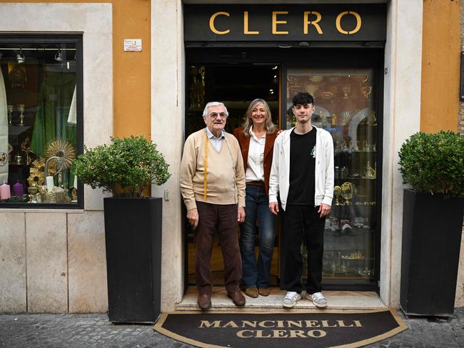 Mr Mancinelli poses with his grandson Lorenzo di Toro and his daughter outside their shop. Picture: AFP
