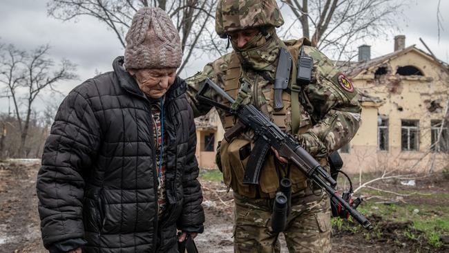 MARIUPOL, UKRAINE - 2022/04/14: A Russian soldier updates a local woman who had been sheltering underground for over a month about the situation in Eastern Mariupol. The battle between Russian / Pro Russian forces and the defending Ukrainian forces led by the Azov battalion continues in the port city of Mariupol. (Photo by Maximilian Clarke/SOPA Images/LightRocket via Getty Images)