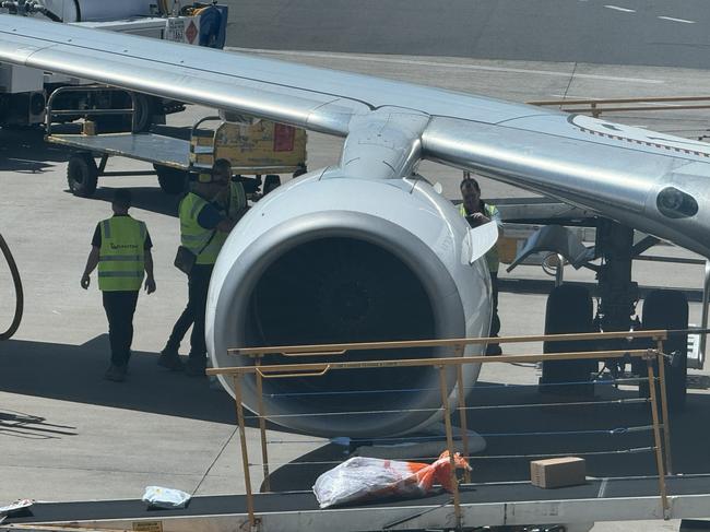 08-11-2024 - Qantas flight QF520 returns to Sydney Domestic terminal 3. Pictured are engineers inspecting the right-side engine which failed