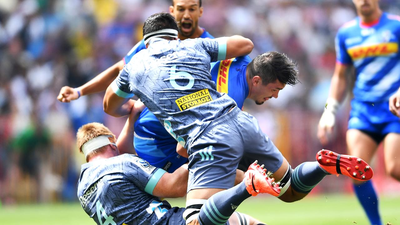 Jaco Coetzee of the Stormers is tackled by James Blackwell and Reed Prinsep of the Hurricanes.