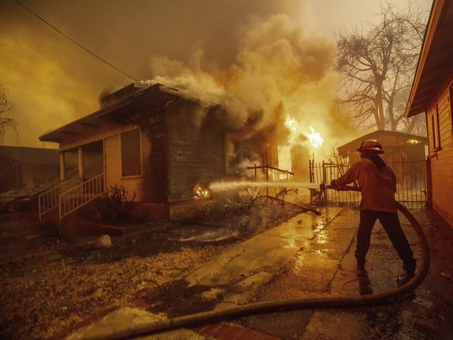 A firefighter battles the Eaton Fire Wednesday, Jan. 8, 2025 in Altadena, Calif. (AP Photo/Ethan Swope)