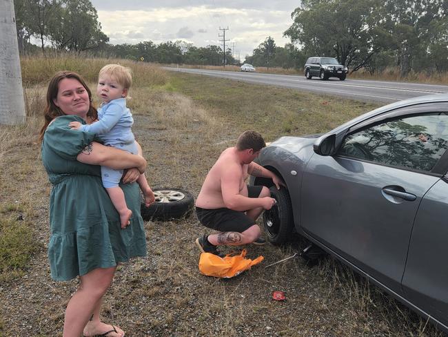 Katrina Worboys with her partner Branden Hellyer and their son Alijah, after blowing a tyre in a massive pothole on the Bruce Highway near Bajool. Photo Darryn Nufer.