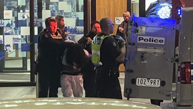 The driver is led away by police following the crash on Friday evening in Bourke Street, Melbourne.