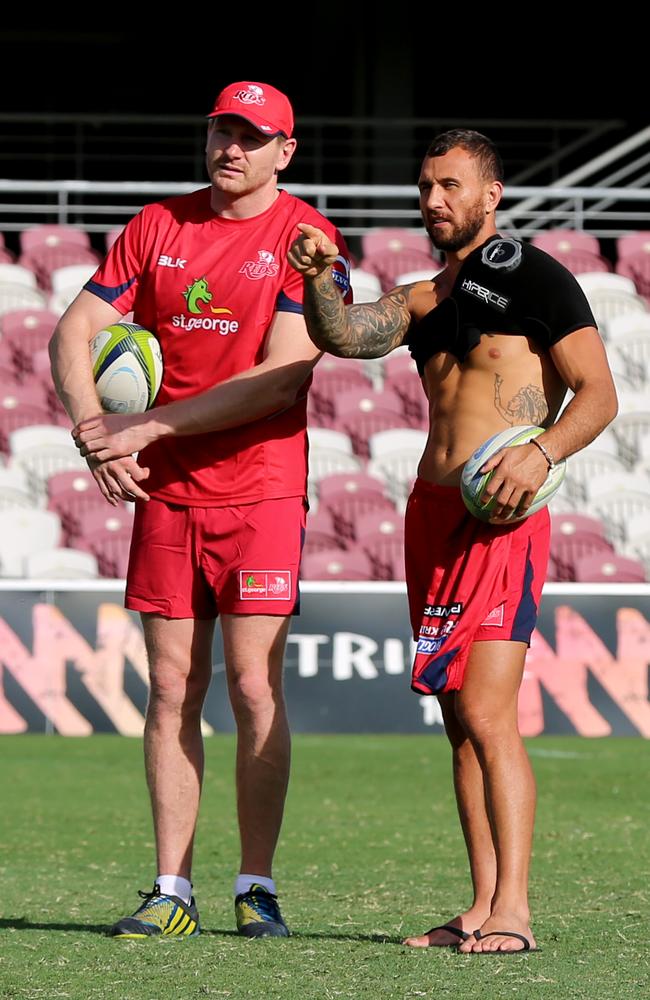 Reds recruit Adam Thomson chats to Quade Cooper at Ballymore.