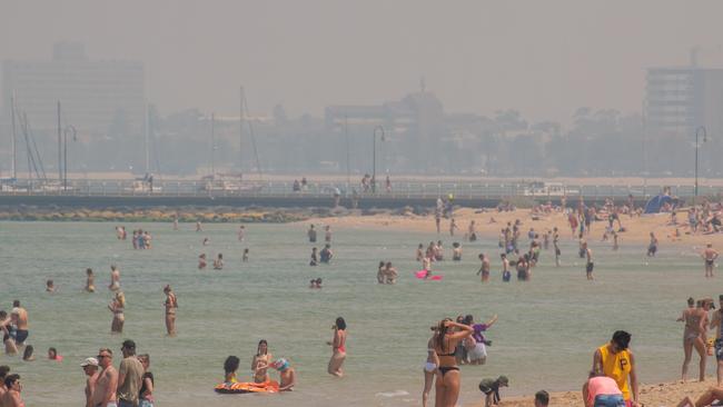 St Kilda beachgoers cool off under a dense smoke haze. Picture: Jason Edwards