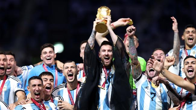 Lionel Messi of Argentina lifts the FIFA World Cup and was forced to wear this robe