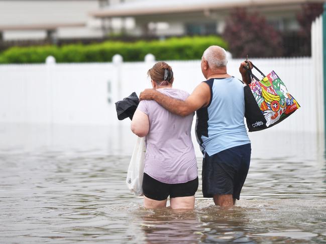 Robin Webb and Ken Leon leave their house with what belongings could be salvaged. Picture: Alix Sweeney