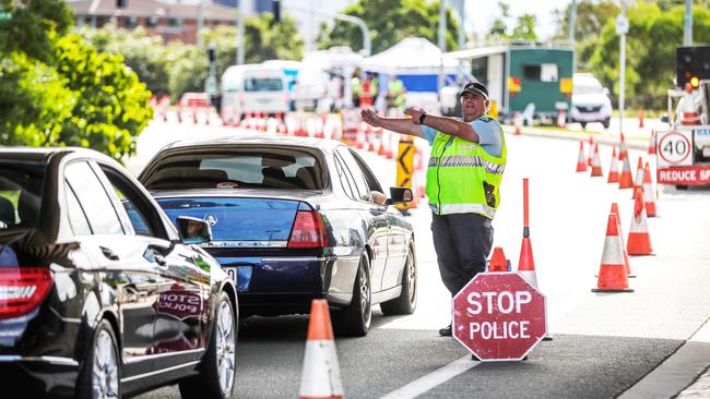 A police officer guides vehicles at the Queensland/New South Wales border. Picture: Nigel Hallett