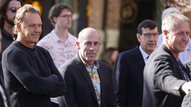 Surfing writer Nick Carroll (centre) who spoke at the funeral, with surf life saving legend Guy Leech, outside St Matthews Anglican Church in Manly. Picture: Tim Hunter.