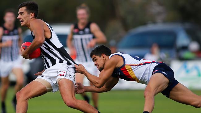 Riley Bonner of Port tackled by Charlie Cameron of the Crows during an SANFL clash last season. There is plenty of support for the two teams remaining in the state league. Picture: Matt Turner.