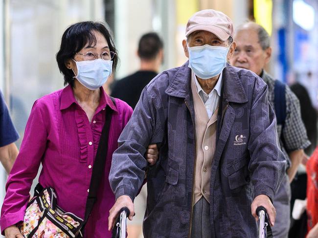 An elderly couple wearing protective face masks to contain the spread of COVID-19. Picture: James Gourley