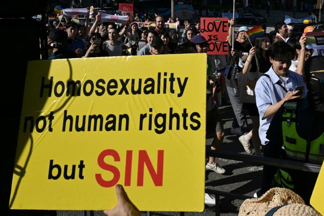 LGBTQ supporters march past anti-gay activists during the annual Pride Parade in Seoul in June