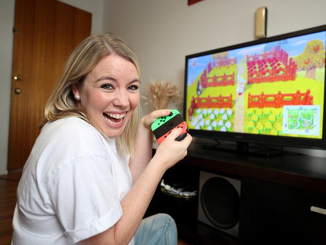 Clare Christensen playing on a console at her home. Picture: Peter Wallis