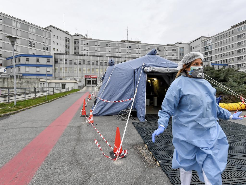 A paramedic walks out of a tent that was set up in front of the emergency ward of the Cremona hospital, northern Italy. Picture: Claudio Furlan/Lapresse via AP, file