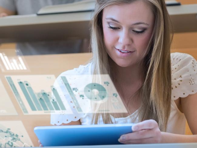 CAREERS FOR DECEMBER: Pretty blonde student in university working on her futuristic tablet analysing graphs.