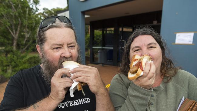 Tony and Shiralee Bateman enjoy their democracy sausage from a fundraiser for the Harristown State High School chaplain in the Queensland state election, Saturday, October 31, 2020. Picture: Kevin Farmer