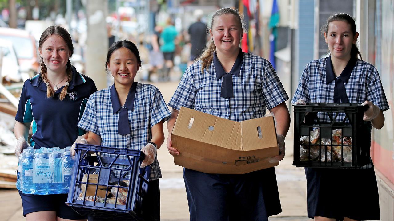 Summerland Christian College students (l to r) Lani Blunn, Sophia Su, Saffron Anderson and Sophia Alvarez, all 14, deliver food and water to people cleaning up. Picture: Toby Zerna