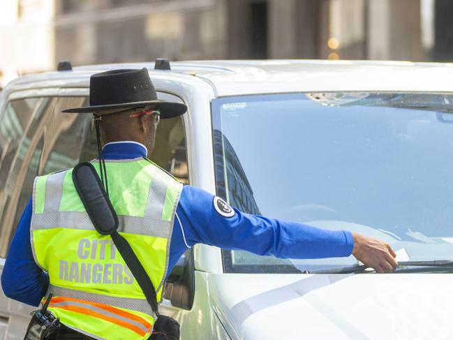 SYDNEY, AUSTRALIA - NewsWire Photos NOVEMBER 15, 2020:  A city ranger is seen putting a parking fine on a car in SydneyÃs CBD. Picture: NCA NewsWire / Jenny Evans