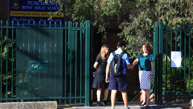 Teachers greet students in front of Punchbowl Boys High school yesterday. Picture: Adam Taylor