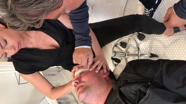 Video still shows John Ibrahim as he waxes the eyebrows of Ryan Watsford who had allegedly been caught stealing $30,000 from his brother Michael Ibrahim. Picture: Supplied