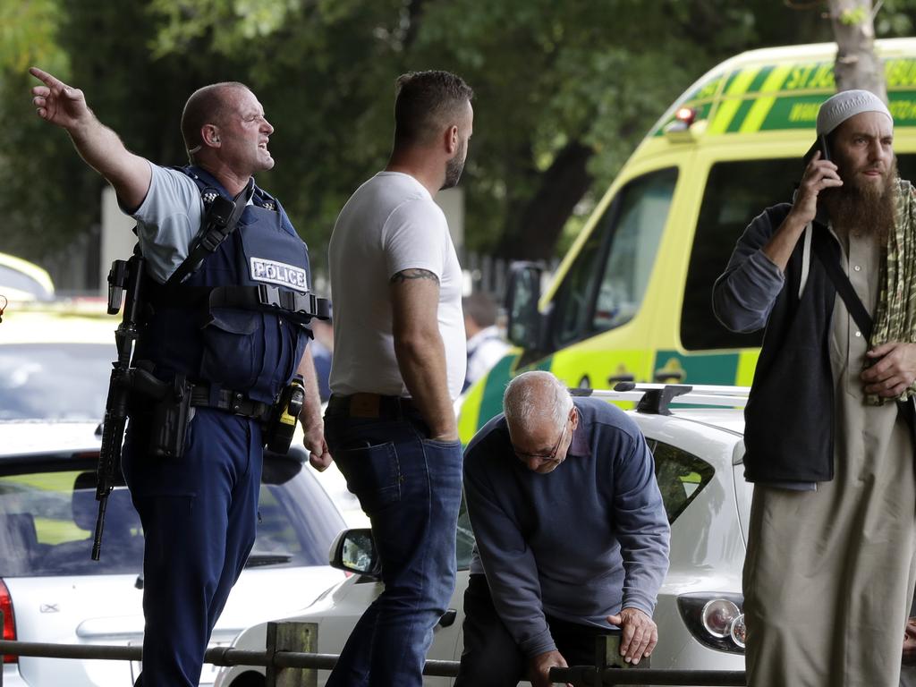 Police attempt to clear people from outside a mosque in central Christchurch, New Zealand, Friday, March 15, 2019. (AP Photo/Mark Baker)