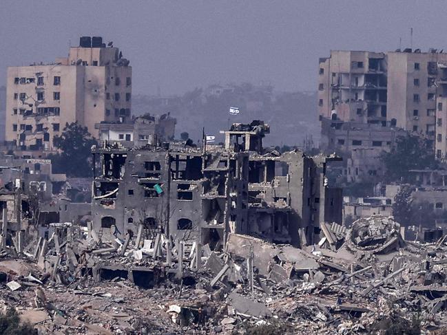 Israeli flags flying over destroyed buildings inside the Gaza Strip. Picture: AFP