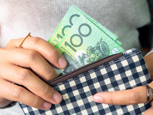 Woman put dollar australia money into wallet.