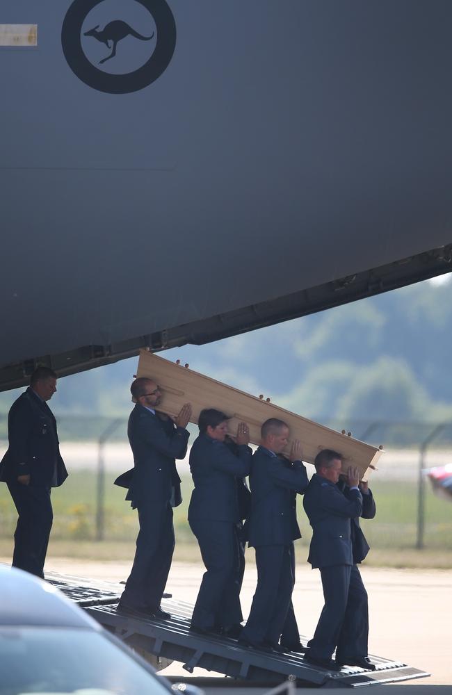 Dutch military personnel carry a coffin containing an unidentified body from the crash of MH17 from a Royal Australian Air Force C47 to a waiting hearse at Eindhoven airport, Netherlands. Picture: Peter Macdiarmid