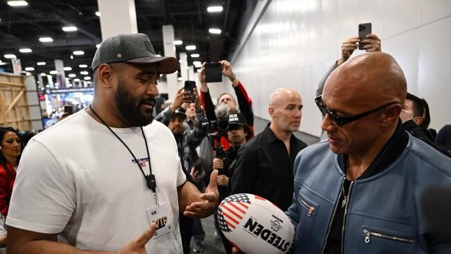 Dwayne 'The Rock' Johnson (right) holding a rugby league football with Australian NFL star and former NRL hopeful Jordan Mailata ahead of next month's games in Las Vegas. Credit: Supplied.