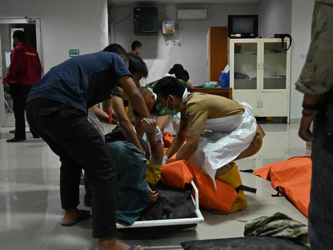 People handle the body of a deceased after the earthquake at a hospital in Cimacan, Cianjur. Picture: AFP.