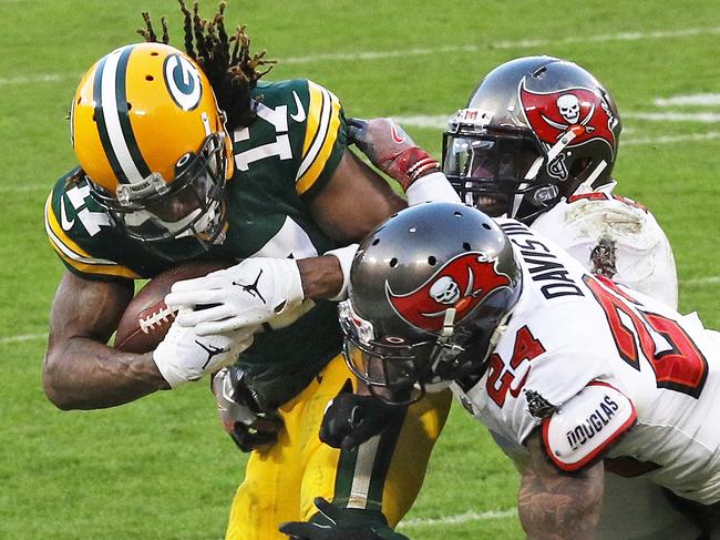 GREEN BAY, WISCONSIN - JANUARY 24: Davante Adams #17 of the Green Bay Packers tries to avoid the tackle of Carlton Davis #24 of the Tampa Bay Buccaneers in the third quarter during the NFC Championship game at Lambeau Field on January 24, 2021 in Green Bay, Wisconsin. (Photo by Dylan Buell/Getty Images)