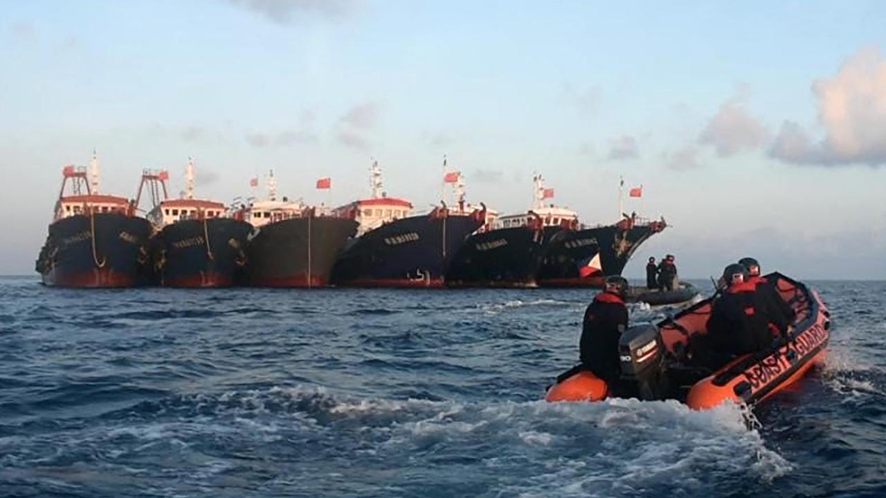 Philippine coast guard aboard rubber boats patrol past Chinese vessels at Whitsun Reef, in the Spratly Islands. Picture: Philippine Coast Guard (PCG)/AFP