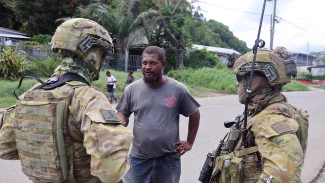 Australian soldiers conduct a brief patrol of a burnt out area in China Town, Honiara. Picture: Gary Ramage.