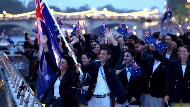 PARIS, FRANCE - JULY 26: Jessica Fox and Eddie Ockenden, Flagbearers of Team Australia, wave the flag on the athletes' parade team boat along the River Seine during the opening ceremony of the Olympic Games Paris 2024 on July 26, 2024 in Paris, France. (Photo by Quinn Rooney / POOL / AFP)