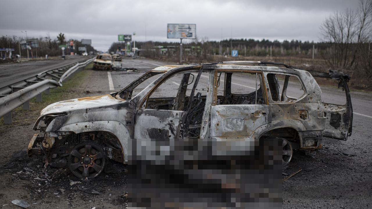 A burnt corpse is seen by a burnt car on the road between Myla and Mriia. Picture: Alexey Furman/Getty Images