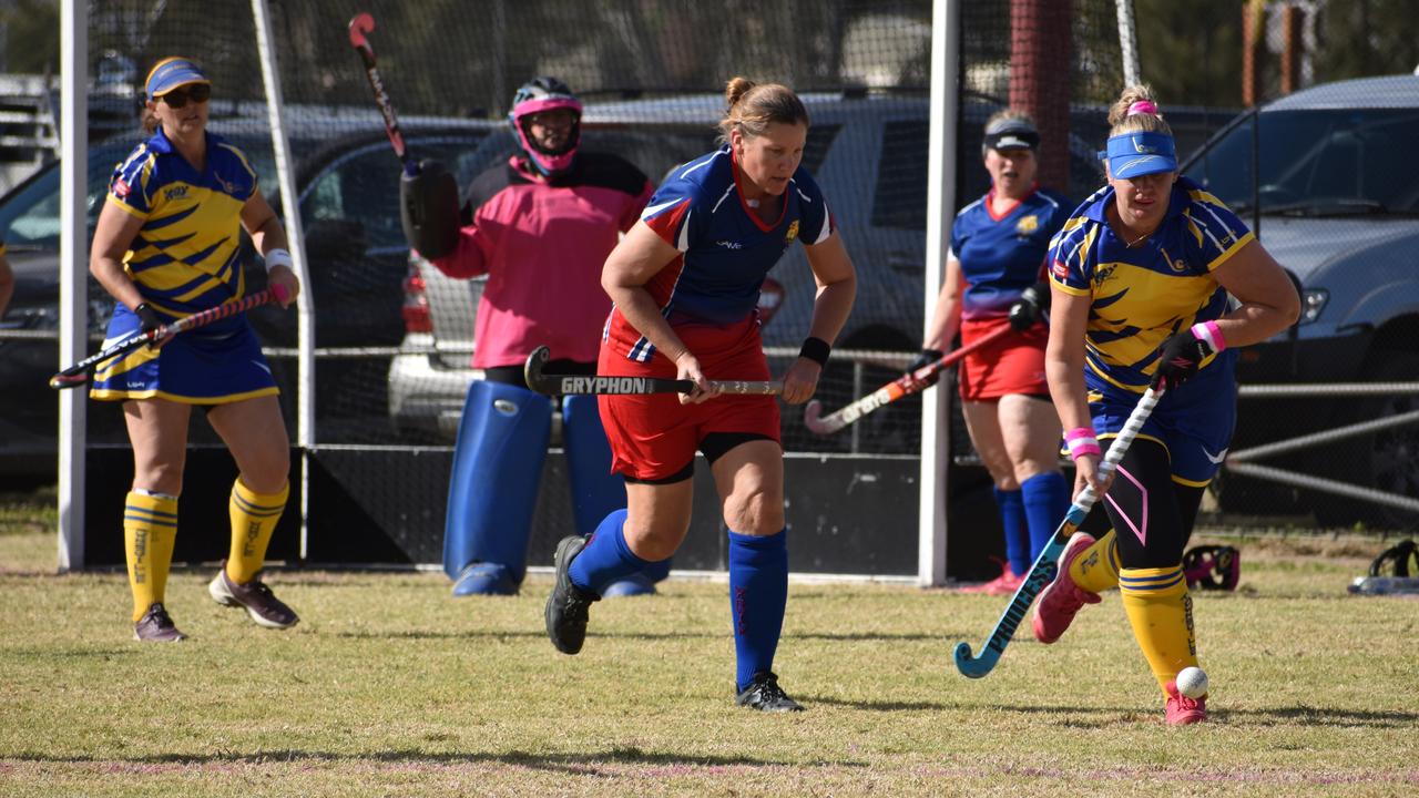 Warwick's Angela Groves and Townsville's Kirsty Reason spring down the field in pursuit of the ball at the 2021 Queensland Hockey Women's Masters Championship at Queens Park.