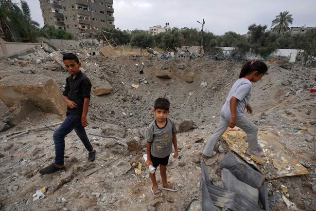 Palestinian children near the crater left by an Israeli strike in Nuseirat in the central Gaza Strip on June 3, 2024