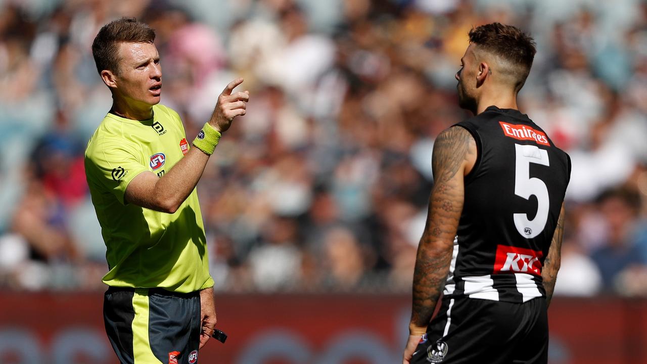 Umpire David Harris counts the numbers of players for Collingwood.