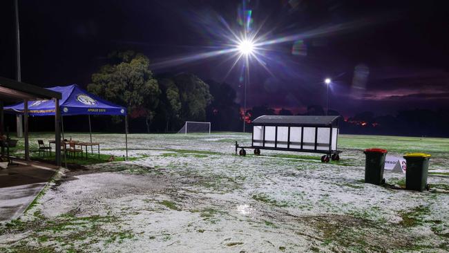 Hail is seen covering a Thornbury oval after a storm hit parts of the northern suburbs on Saturday. Picture: Brendan Beckett