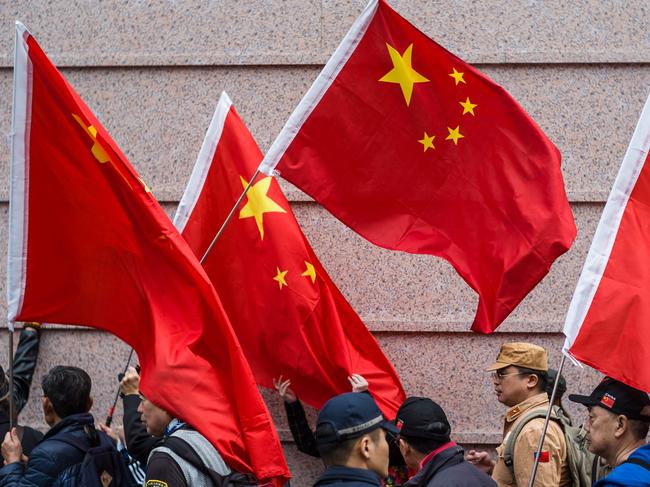 Activists shout slogans while holding China's flag as they gather outside the building that houses the Japanese embassy in Hong Kong on December 13, 2018, to mark 81 years since the 1937 Nanjing massacre. - China says 300,000 people died in a six-week spree of killing, rape and destruction by the Japanese military that began in December 1937 after invading troops seized the city of Nanjing. Some respected foreign academics estimate a lower number of victims, but mainstream scholarship does not question that a massacre took place. (Photo by ANTHONY WALLACE / AFP)